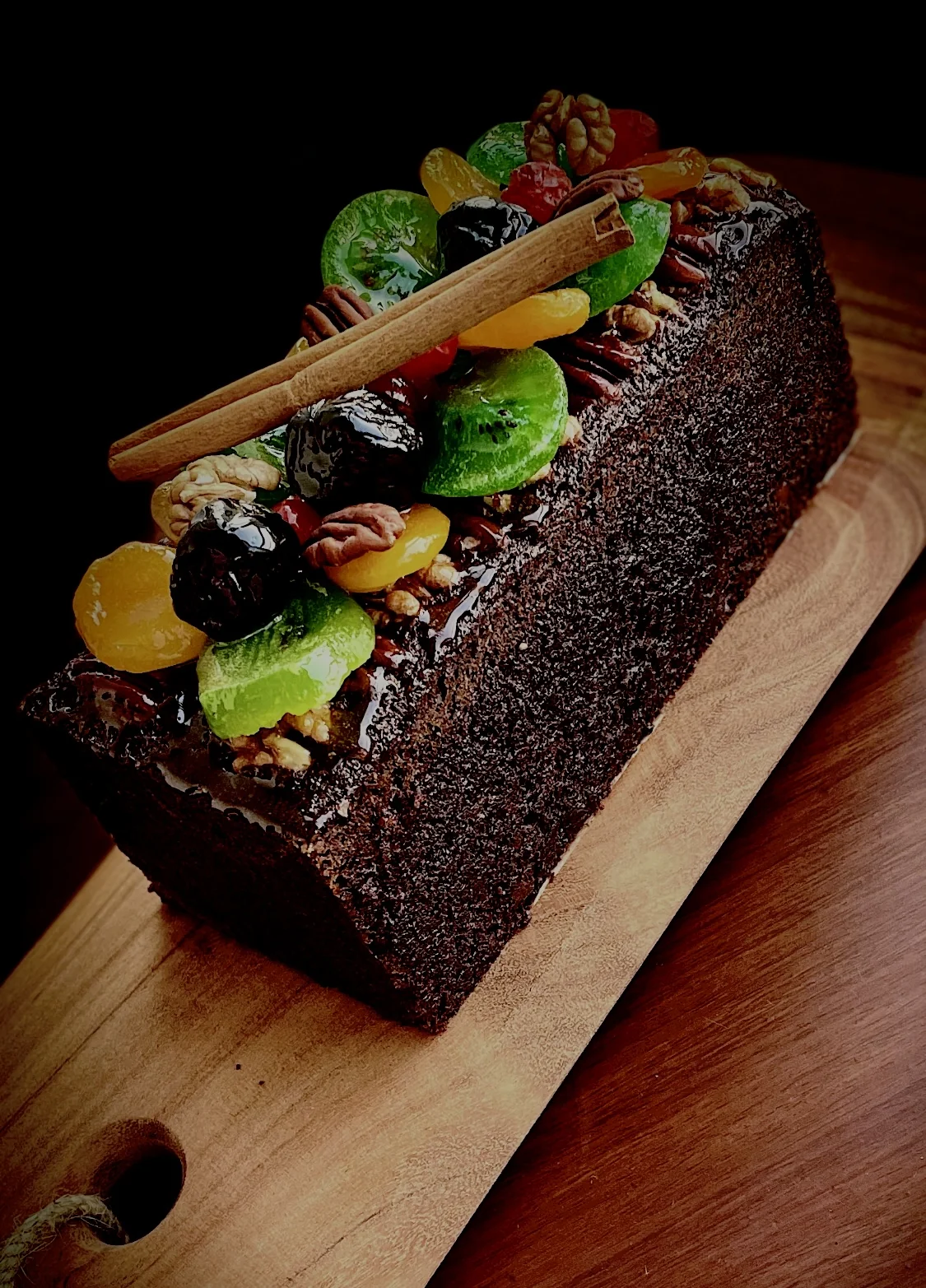 Cake aux Fruits — dark chocolate loaf crowned with glacé fruits, toasted walnuts and pecans